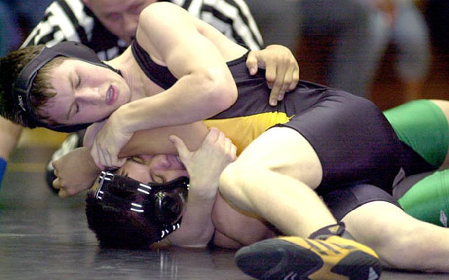 Branden McCullough of Kadena cradles Carl Tapang of Kubasaki during the 129-pound bout. McCullough pinned Tapang in 1 minute, 44 seconds.