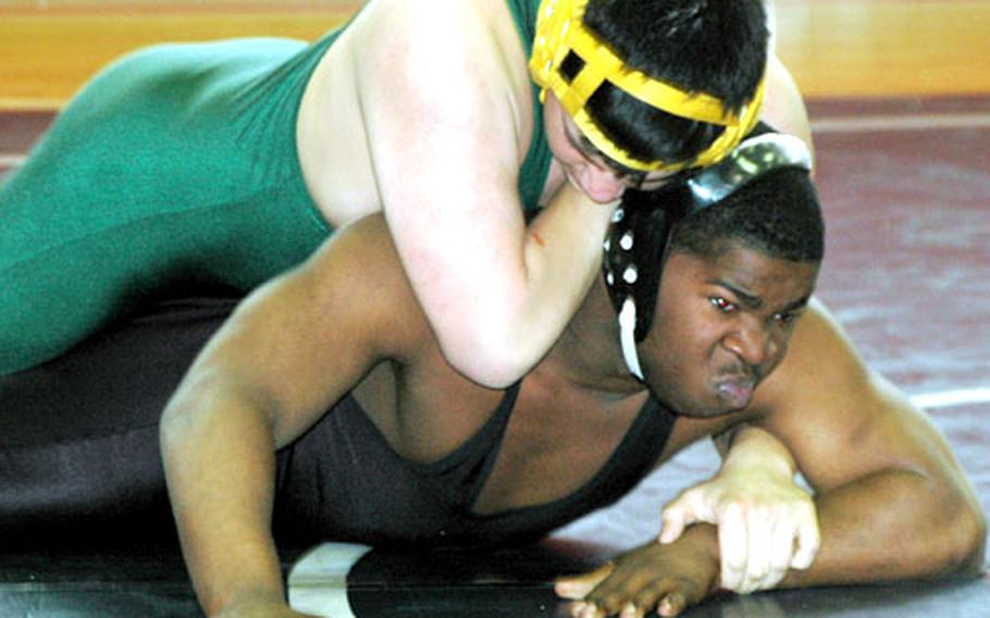 Kiko Bratcher, in green, of Robert D. Edgren gets the upper hand on Charles “The Steamroller” Howard of E.J. King during their 180-pound weight class bout (won by Bratcher) Saturday at Sasebo Naval Base. The DODDS-Japan Invitational Wrestling Tournament at the E.J. King Gymnasium featured teams from E.J. King, Zama American, Nile C. Kinnick, Yokota and Robert D. Edgren high schools.