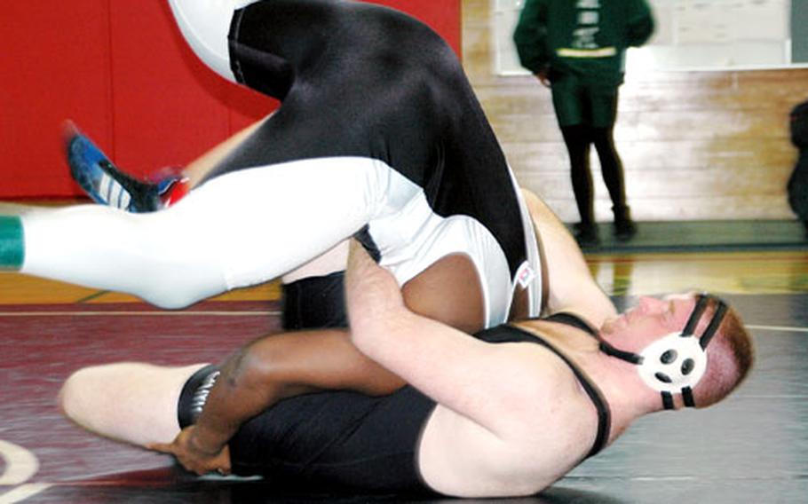 Zama High School’s David Burnett, wearing black and white, is lifted by teammate Justin Planty, wearing solid black, during their inter-squad heavyweight match at Ernest J. King High School Saturday at Sasebo Naval Base. With a lack of heavyweights in the 275-pound class, the two Camp Zama wrestlers faced each other in an elimination match.