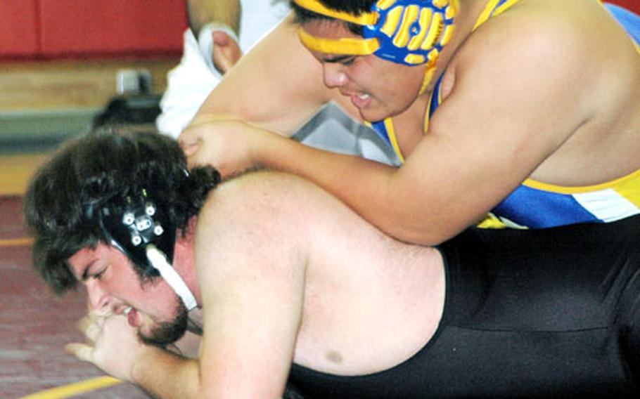 Ernest J. King High School’s heavyweight Richard Baker, wearing black, fights off Randall Pelletier of Yokota High School in a match Pelletier won Saturday at Sasebo.