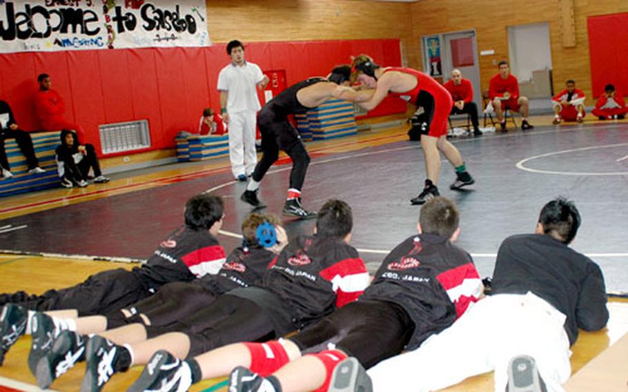 Members of the Ernest J. King High School wrestling team watch a teammate compete.