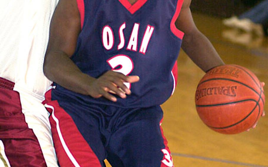 Tyrone Bullocks of the Osan Defenders tries to find room around Keith McCauley of Truth, Okinawa, during Monday’s championship game in the 2nd Kadena Basketball Classic at Falcon Gym, Kadena Air Base, Okinawa. Truth won 74-66.