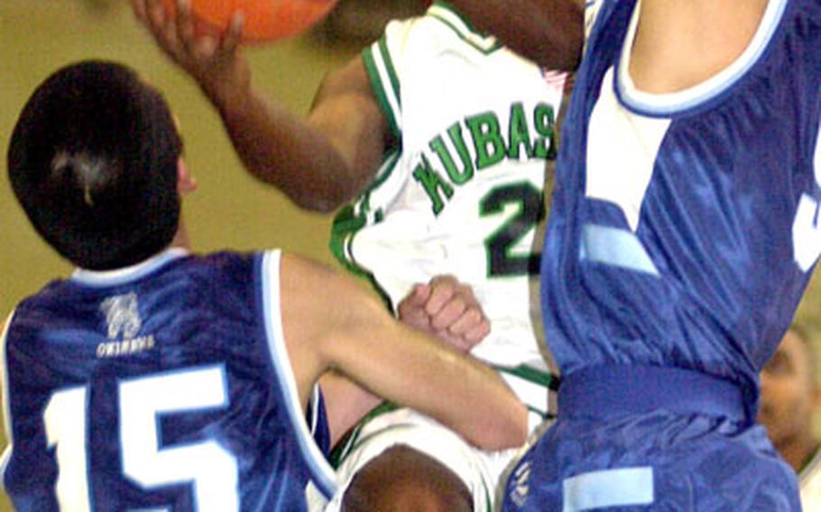 Kubasaki guard Thaddeus Reap gets fouled as he jumps into two Konan defenders during Friday&#39;s game at Camp Foster, Okinawa. Kubasaki won 84-66.