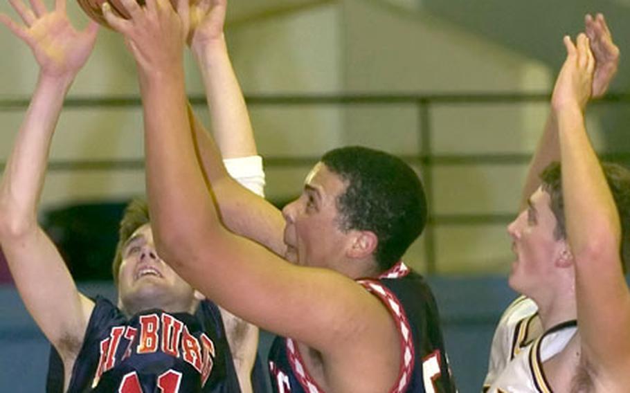 Bitburg&#39;s Nick Brown, center, grabs a rebound between teammate Trey Wilson and Hanau&#39;s Marcus Fontanez.