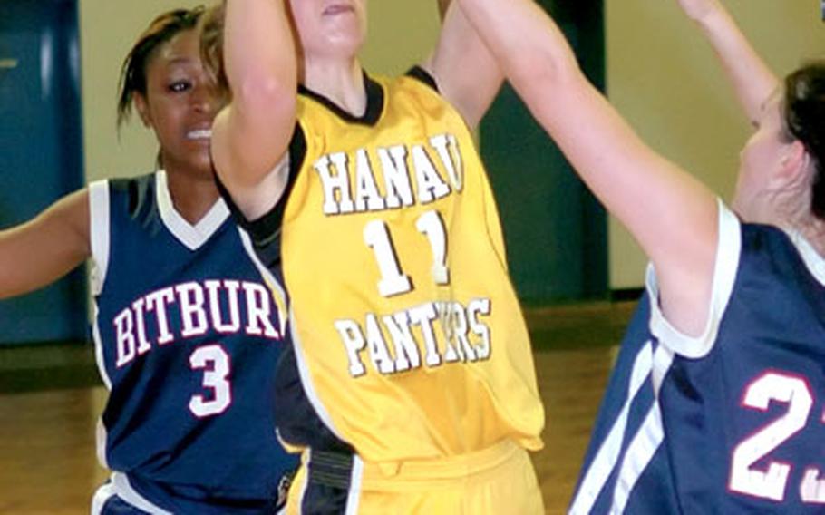 Hanau&#39;s Kyrie Bye-Nagel, center, takes a shot from between Bitburg&#39;s Jazmine Winn, left, and Erica Winters during a DODDS high school basketball matchup in Hanau, Germany, Friday night. Hanau crushed Bitburg 52-15.