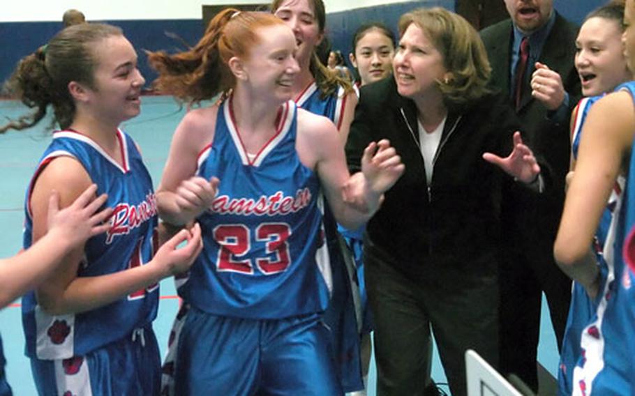 Ramstein players and coaches congratulate Krissy Grosselin (23) center, for a game-winning three-point play against International School of Brussels at Ramstein, Germany, on Saturday.