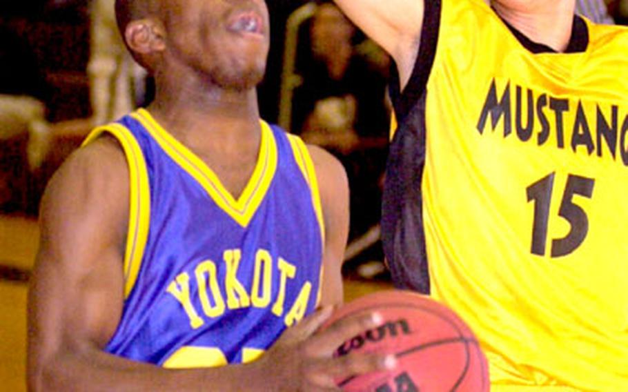 Yokota Panthers guard Cameron Cooper drives for two of his 30 points as American School In Japan Mustangs guard Tatsuya Izumi defends during Wednesday’s game in Tokyo. Yokota won, 55-45.