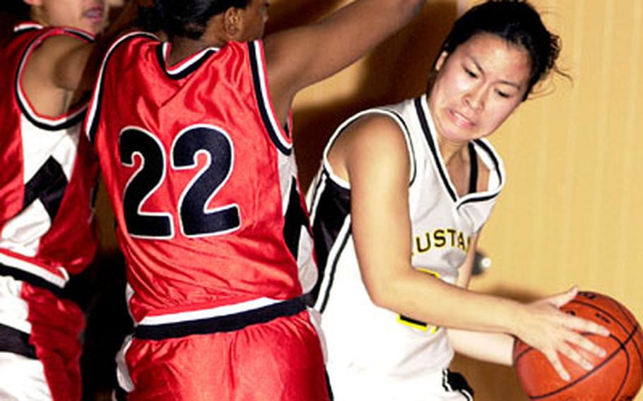 Nile C. Kinnick defenders Jasmine Jordan and Tomika Lynce bottle up American School In Japan Mustangs guard Momoko Cunneen during Wednesday&#39;s Kanto Plain Association of Secondary Schools game at Tokyo. Using a 3-2 press, Kinnick scored the first 20 points and kept ASIJ scoreless for the first 7:21 in a 50-26 victory.