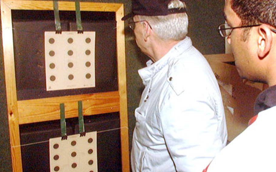 Bruce Andrews, coach of the Hohenfels High School rifle team, checks the marksmanship of a competitor during the 2003 European high school rifle championships. The 2004-05 rifle season was cancelled because of safety concerns with rifle ranges.