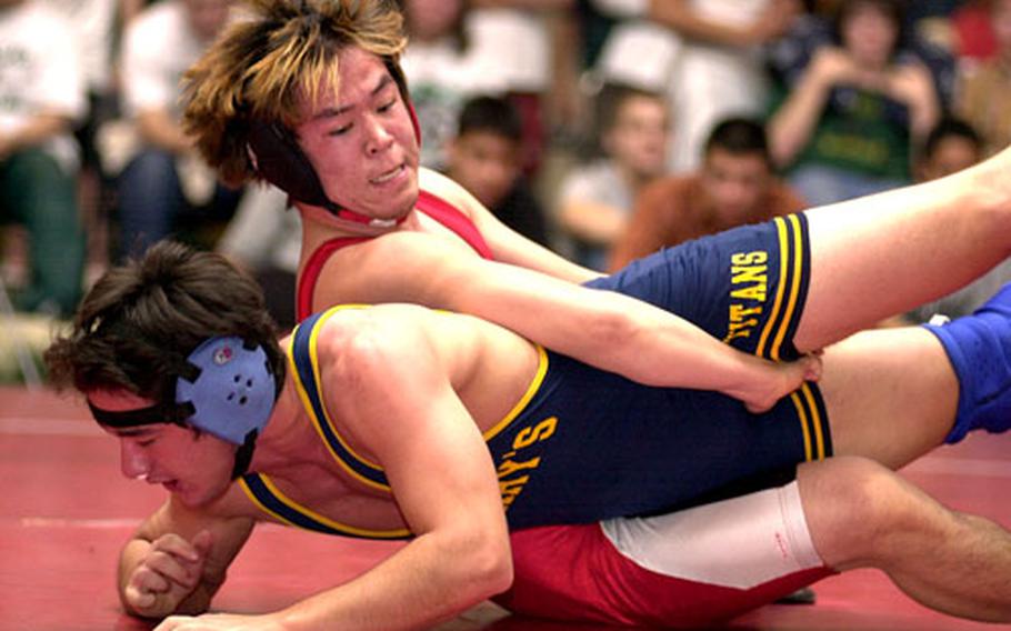Yamato Cibulka, top, of Nile C. Kinnick tries to leg-tilt Sonny Libero of St. Mary's International during the 158-pound championship bout of Saturday's Nile C. Kinnick Invitational Wrestling Tournament at Yokosuka Naval Base, Japan. Cibulka decisioned Libero 10-5.