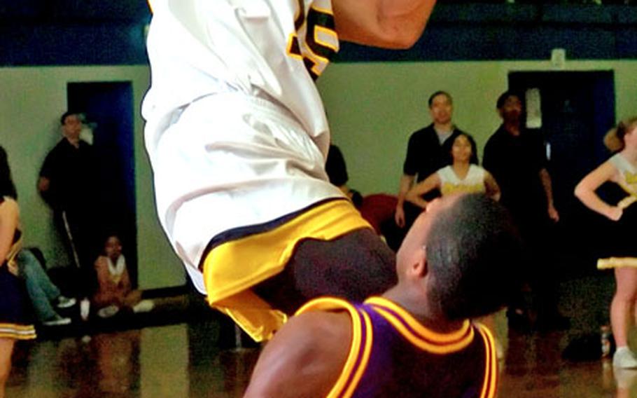Hanau's Malcolm Lane, elevates over Mannheim's Ricky Gardner while driving to the hoop during a DODDS high school basketball game Friday night in Hanau, Germany. Hanau knocked off Mannheim 69-56.