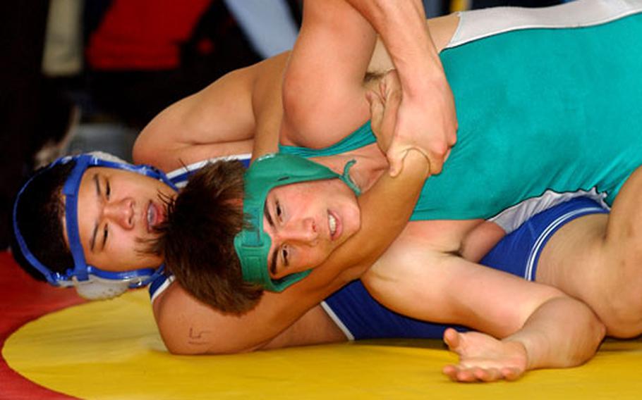 London Central&#39;s Ivan Linatoc, left, has a grip on Adam Beveridge of Ankara in a 215-pound first-round match at the DODDS European wrestling finals at the Wiesbaden Army Airfield on Friday. Beveridge turned the tables and won to advance to the next round.