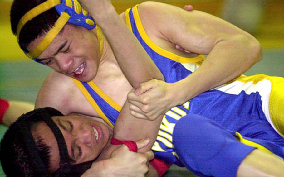 Patrick Pamintuan, top, of Yokota locks up Bobby Antonio of Nile C. Kinnick in a head-and-arm hold during Friday&#39;s 108-pound championship bout of the individual freestyle portion of the Far East High School Wrestling Tournament at Yokota High School. Pamintuan pinned Antonio in 40 seconds.
