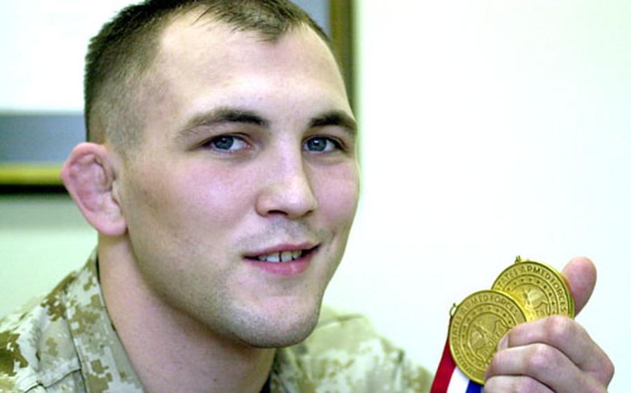 Marine Corps Cpl. Jacob Clark shows off his newest gold medals.