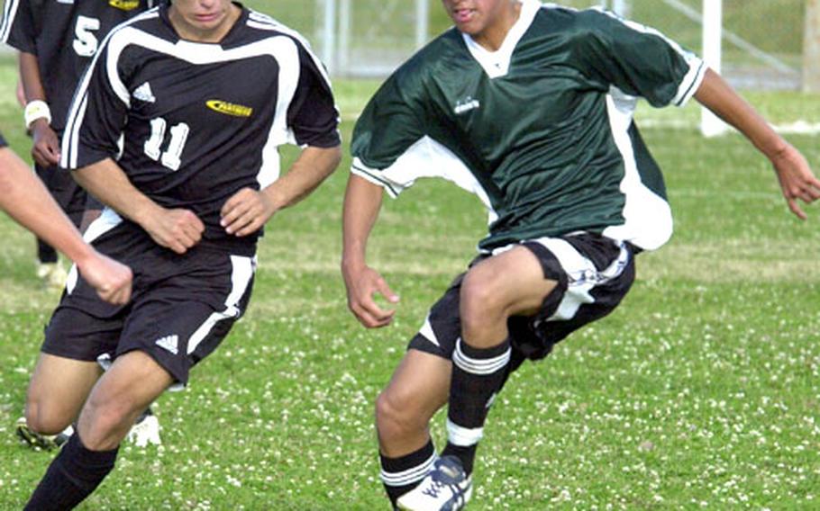Brenden Stanford (11) of the Kadena Panthers and Daniel Ihu of the Kubasaki Dragons battle for the ball during Thursday&#39;s soccer match at Camp Foster, Okinawa. The two-time Class AA champion Panthers shut out the Dragons 3-0.