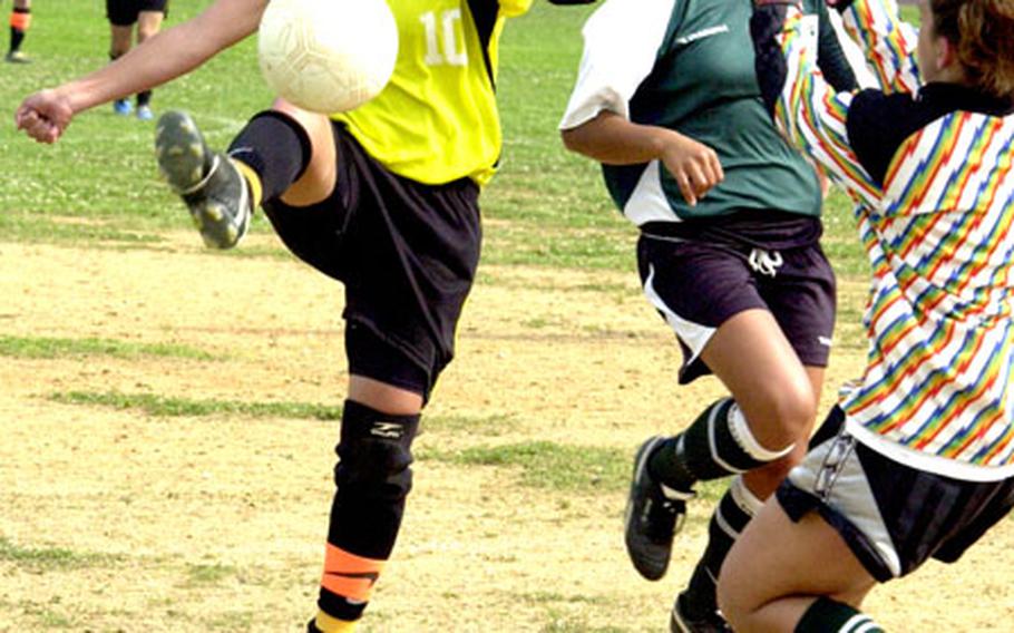 Kadena forward Dianne Abel tries to control the ball as Kubasaki defender Kady Wolf, back right, and goalkeeper Amanda Caskey defend during Friday&#39;s game at Kadena High School, Okinawa. Abel had two assists as Kadena won 3-1.