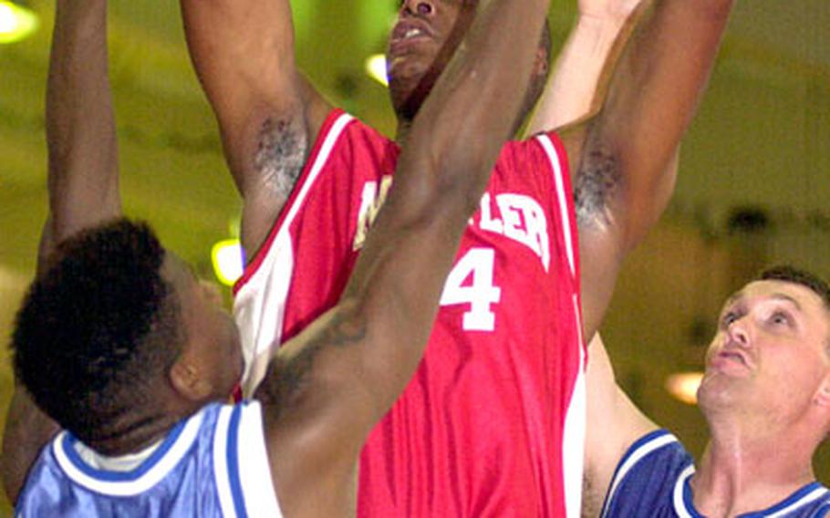 Robert Avery of Marine Corps Base Camp Butler puts up a shot between defenders Tony Winters (11) and Joshua Reaser (14) of 1st Marine Aircraft Wing during Thursday&#39;s semifinals. Base rallied from a 12-point first-half deficit to reach its second straight final, beating Wing 71-50.