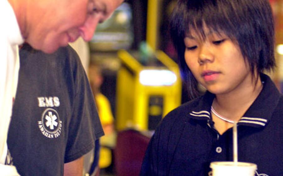 Randy Pedersen signs an autograph for Suzuna Miyagi during Friday’s “Beat the Pro” appearance at Kadena Air Base, Okinawa.