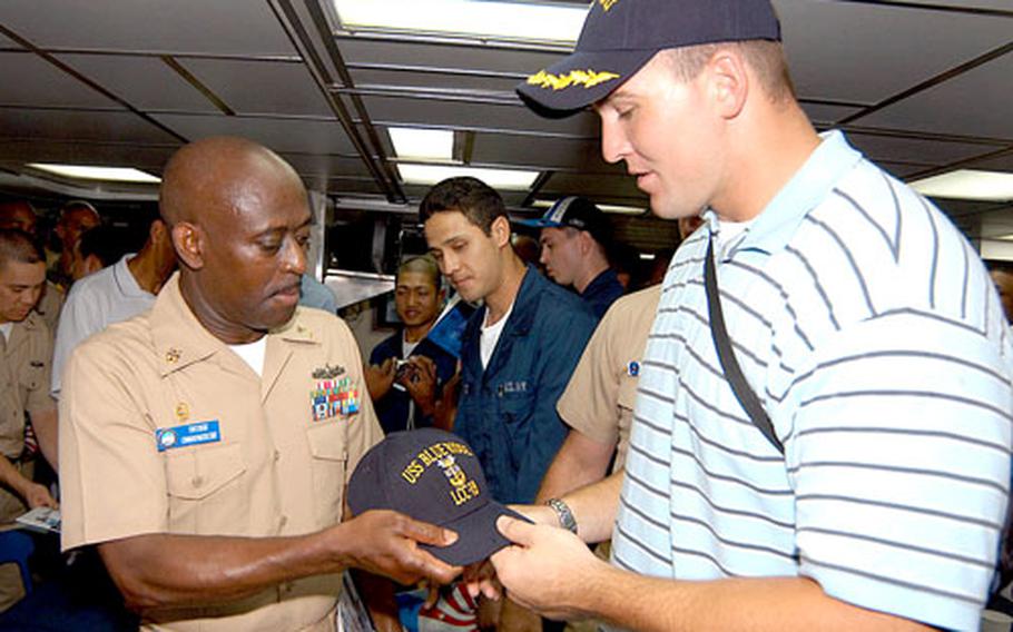 USS Blue Ridge Command Master Chief Anthony Knight presents Indianapolis Colts tight-end Ben Hartsock with a Blue Ridge Master Chief’s cover on the mess decks aboard the Blue Ridge. The Indianapolis Colts players and cheerleaders met with sailors to sign autographs aboard the 7th Fleet flagship in Yokosuka, Japan. The Colts were in Japan for Saturday’s Americal Bowl against the Atlanta Falcons at the Tokyo Dome.
