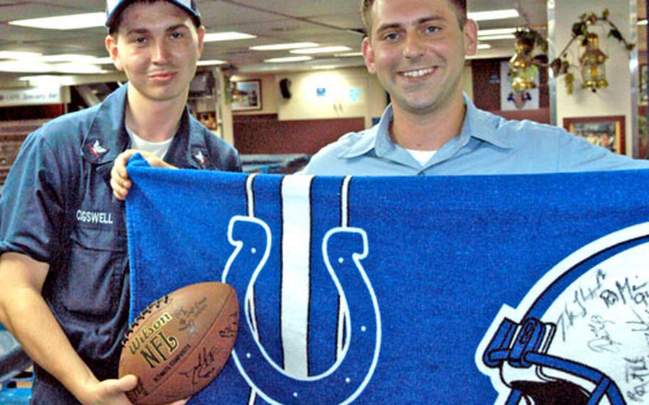 Colts fans Petty Officer 3rd Class Michael Cogswell, left, and Seaman Travis Lasley display their bounty of autographs after meeting some of the players.