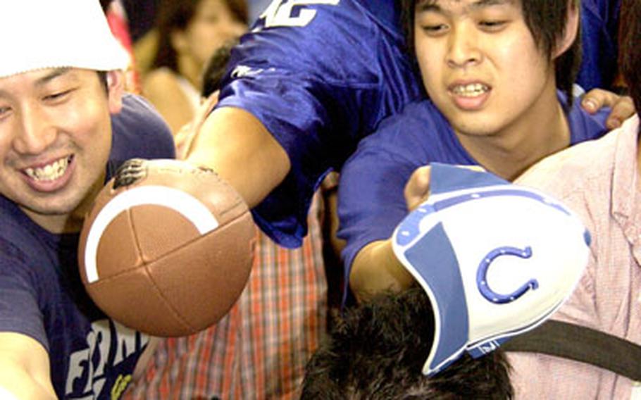 Navy Lt. Chris Hubbard of Atsugi Naval Air Facility, Japan, pushes his way through Japanese fans to get an autograph.