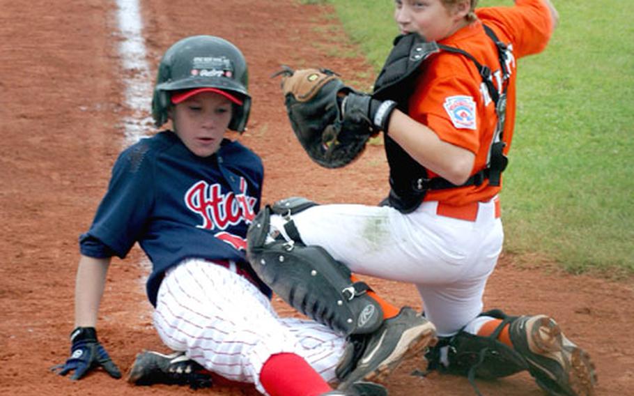 Derrick Rovito of Naples, Italy, slides home safely in the fifth inning with the go-ahead run past catcher Sam Phillips of Brunssum-Schinnen, Netherlands, during Naples&#39; 2-1 win on Tuesday during the Trans-Atlantic Regional Little League tournament in Vilseck, Germany.