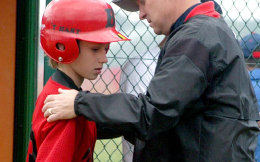 Assistant coach Scott Burr of the Brussels, Belgium team consults with Fons t&#39;Hart Wednesday before a bases-loaded at-bat in the third inning against Ramstein. Brussels lost the game 8-2.