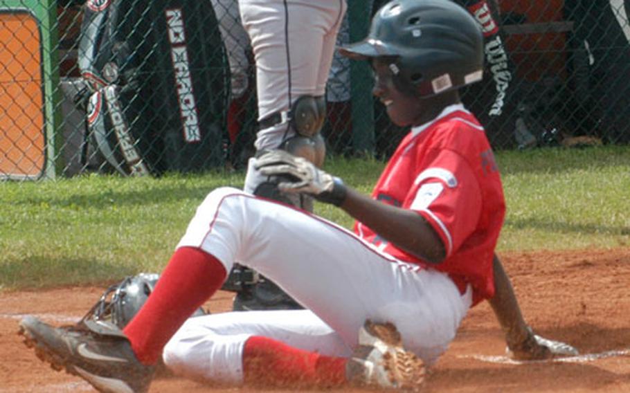 Ramstein&#39;s Andre Porterfield slides home safely against Brussels, Belgium, on Wednesday. Porterfield hit a single and a triple and stole seven bases in the game, scoring four times.
