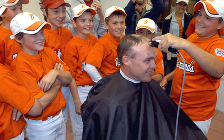 Pitcher Jacob Reynolds of the Brunssum-Schinnen, Netherlands, team (right) shaves the head of assistant coach Ronnie Christopher on Tuesday. Reynolds won the bet for walking only one batter in Netherlands’ 2-1 loss on Tuesday to Naples, Italy in the Trans-Atlantic Regional tournament played in Vilseck, Germany.
