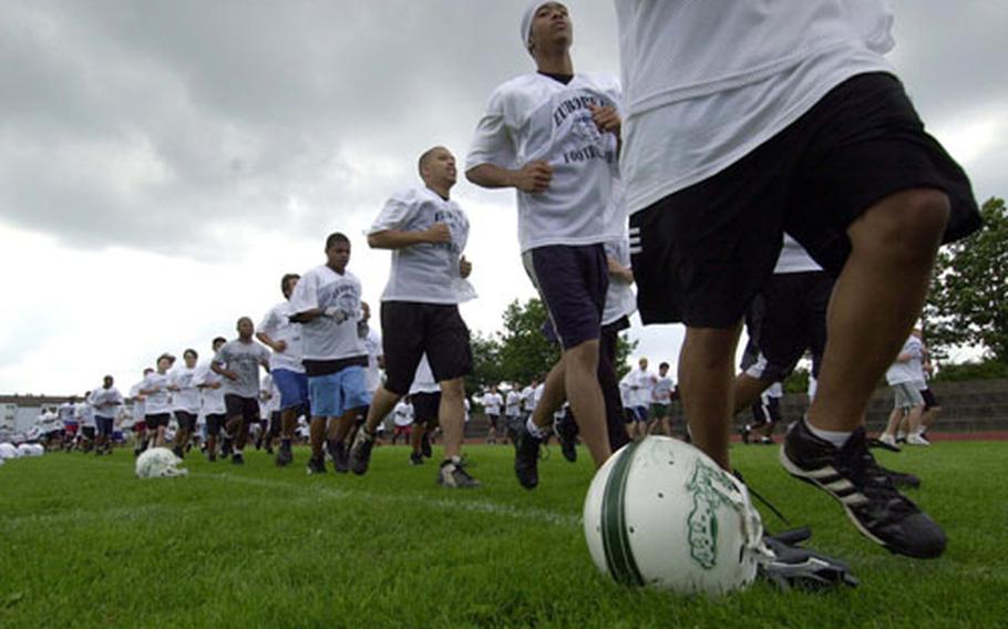 Athletes participating in the DODDS-Europe football camp in Ansbach, Germany run laps around the field at the start of Wednesday&#39;s afternoon session.