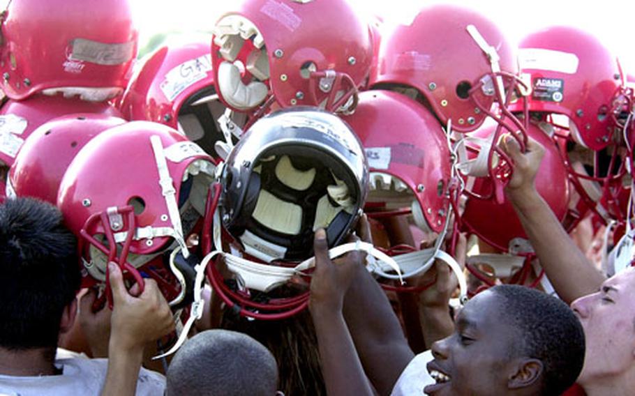 The Nile C. Kinnick Red Devils football team concludes Wednesday’s practice with a “breakdown” cheer at Yokosuka Naval Base, Japan.