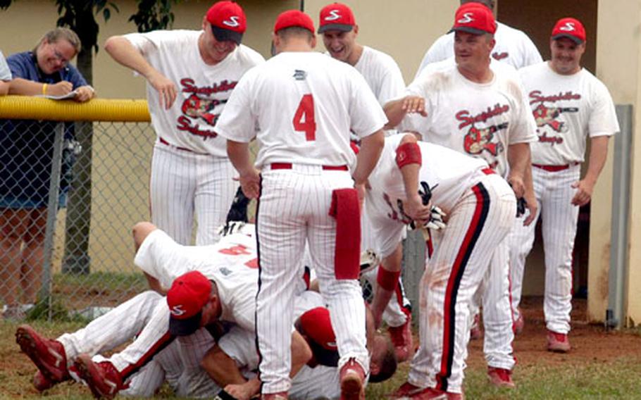 The Spangdahlem men&#39;s softball team celebrates its second straight U.S. Air Forces in Europe title Tuesday by forming a mini-pile after rallying for three runs in the bottom of the seventh to defeat Ramstein, 12-10.