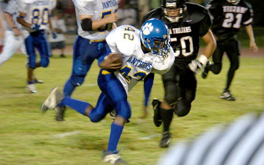 Yokota Panthers sophomore Anthony McNeil evades the Zama Trojans defense during a run for the first touchdown of Yokota’s victory Friday night at Yokota Air Base, Japan.