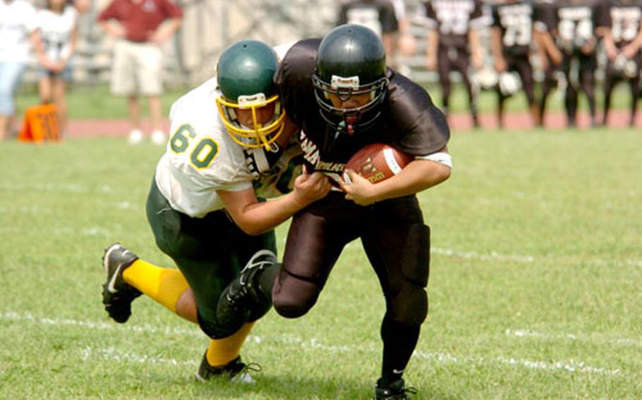 Edgren’s Neil Johnson tackles Zama American’s Christian Sandiko in Saturday’s game at Camp Zama, Japan.