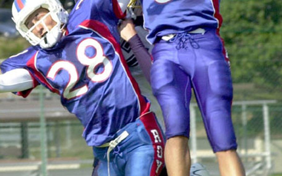 Ramstein High&#39;s Scott Jardine, left, and Ste&#39;phan James, right, close in on a Heidelberg receiver as they try to intercept a halfback pass thrown by Lewis Allen Jr. on Saturday at Ramstein Air Base. Jardine ended up with the interception in Ramstein&#39;s 10-7 win over Heidelberg.