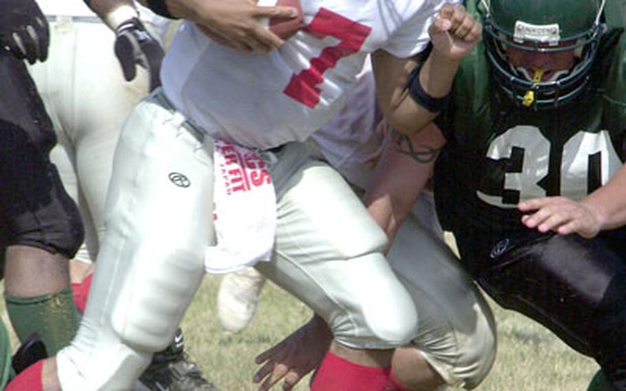 Foster-Futenma backup quarterback Angel Pantoja sneaks 5 yards for a first down through the tackle of Jesus Lira of Courtney-Hansen during Sunday’s season opener at Camp Courtney, Okinawa.