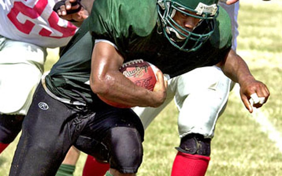 Courtney-Hansen tailback David Burnell eludes the tackles of Foster-Futenma defenders Brandon Collins and Joe King for yardage during Sunday’s game.