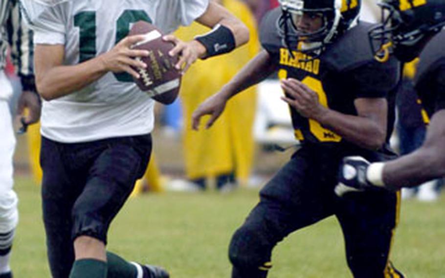 Naples quarterback Tyler Terronez is pressured by Hanau’s Andrew King, center, and Perry Ronderio.