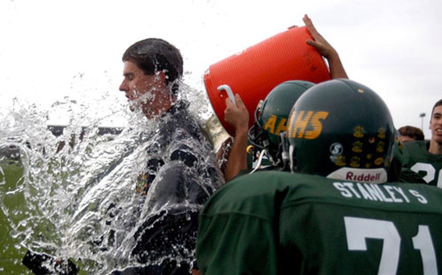 Alconbury football players dump water over head coach Ron Behr after the team won its first game since the start of the 2001 season, beating Brussels 52-36. It was also Alconbury’s homecoming game.