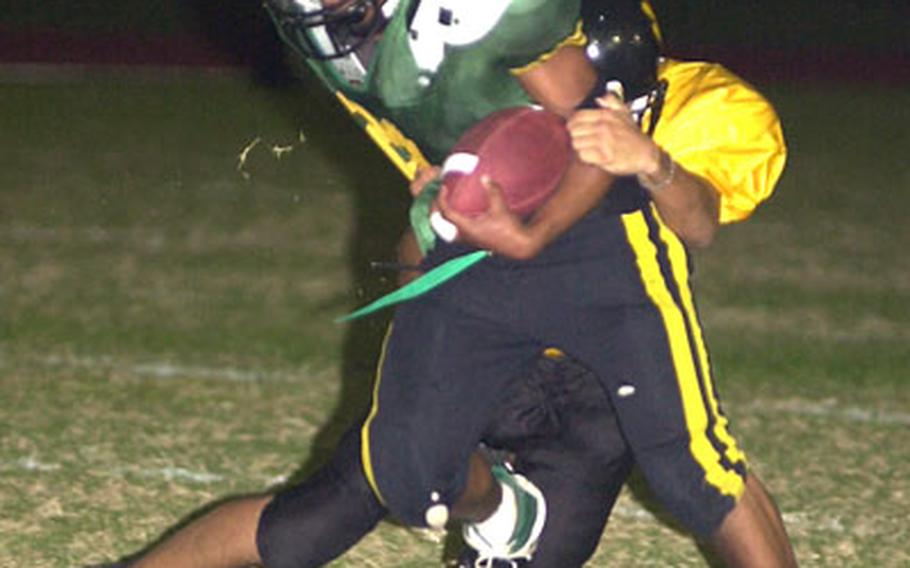 Kubasaki Dragons running back Tim Gardner is wrestled down for a 9-yard loss by Dominique Broussard of the Kadena Panthers during Friday’s game at Camp Foster, Okinawa. Kubasaki routed Kadena 35-3.