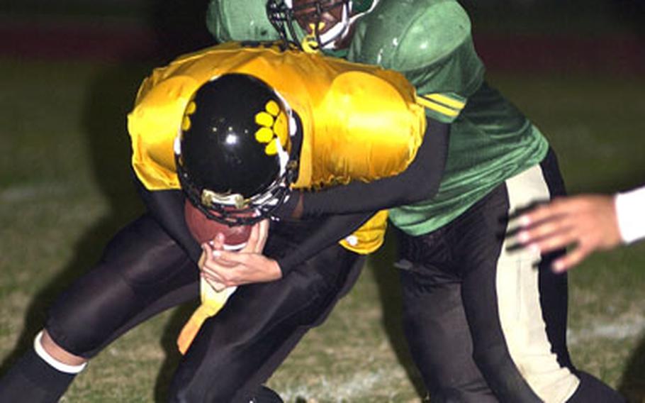 Kadena Panthers quarterback Alex Mierzejewski is sacked by Kubasaki’s Arthur Moore.