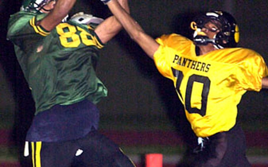 Kubasaki tight end Stephen Thompson, left, reels in a 29-yard touchdown pass from Rafael Mew as Kadena’s David Wyche defends.