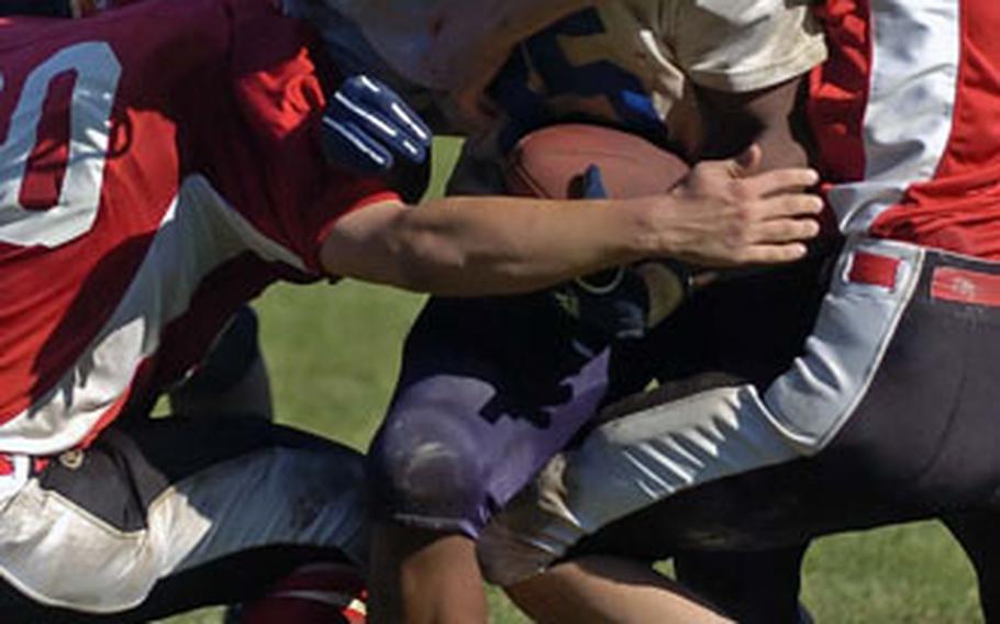 Sigonella’s Mike Petty is tackled by Giessen’s Sean Welton, left and Kyle Burke in the fourth quarter of Sigonella’s 21-6 victory Saturday in Giessen, Germany. Petty rushed for 155 yards and two touchdowns and had 12 tackles and a sack on defense.