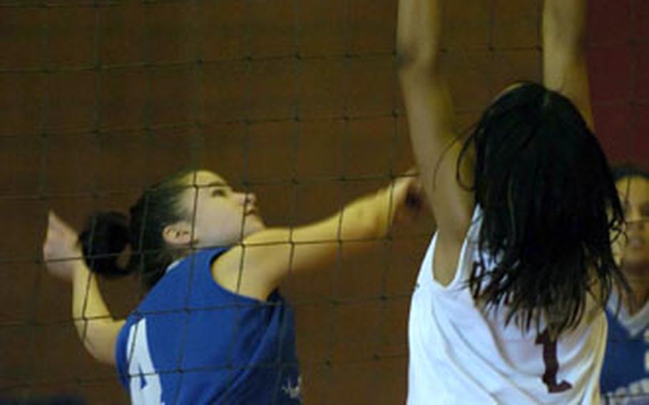 Hohenfels’ Vanessa Velez, left, tries to spike the ball past Baumholder’s Kandi Dyer.