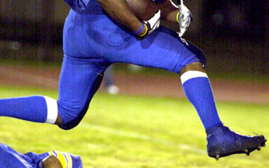 Yokota fullback Mark Dixon hurdles over a blocker en route to an 8-yard touchdown.