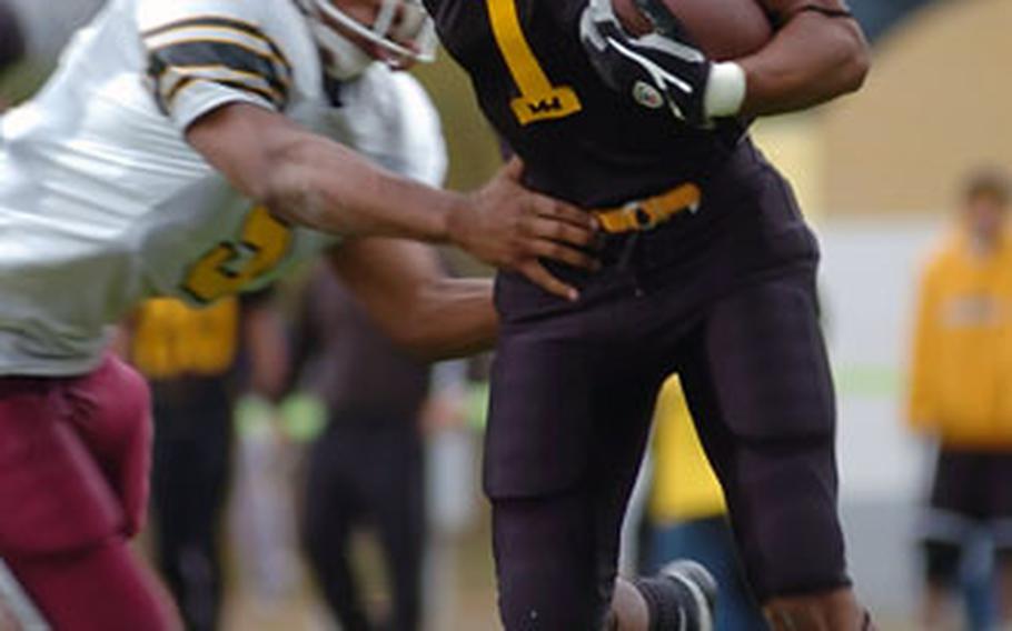 Hanau’s Malcolm Lane runs through the tackle of Baumholder’s Rashad Taylor during a DODDS-Europe Division II quarterfinal football playoff game in Hanau, Germany, on Saturday. Hanau crushed Baumholder 42-8.