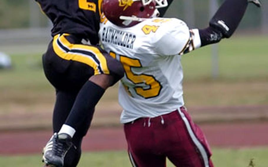 Hanau’s Tre Render, left, catches a touchdown pass over Baumholder’s Joshua Emerson during Saturday’s Division II playoff game.