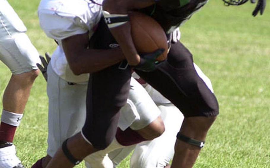 Dragons receiver Tarrick Jackson (3) drags two Kinser defensive backs with him on a pass reception. Jackson caught four passes for 50 yards and two touchdowns.