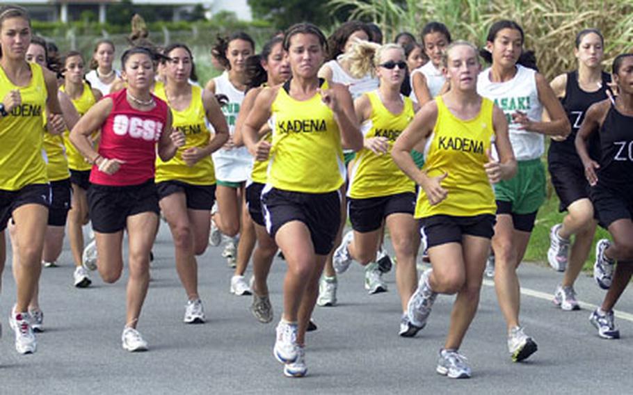 Dianne Abel, center, of Kadena Panthers and teammate Taylor Carver, just to her left, lead the pack past a sugar cane field near Torii Beach at the start of Wednesday&#39;s Okinawa Activities Council all-island cross-country championship girls 3.1-mile individual race at Torii Station, Okinawa.