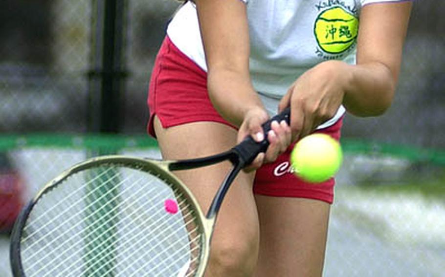 Kubasaki senior Frances Delossantos runs to make a two-handed forehand shot against Katherine Otterson of Kadena during Thursday&#39;s first singles match. Delossantos capped an unbeaten singles season by beating Otterson 6-4.